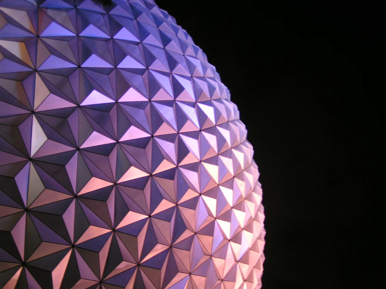Spaceship Earth at Epcot, lit purple against the night sky