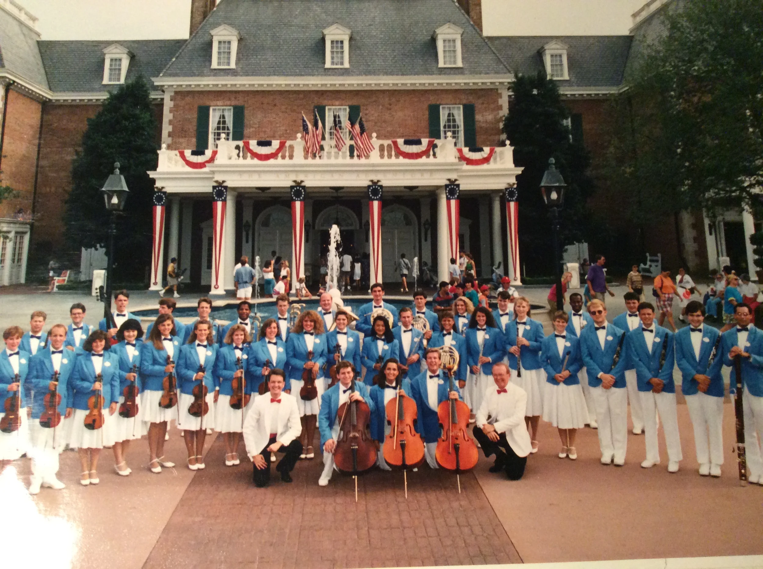 The All-American College Orchestra in blue blazers in front of the American Adventure pavilion at Epcot